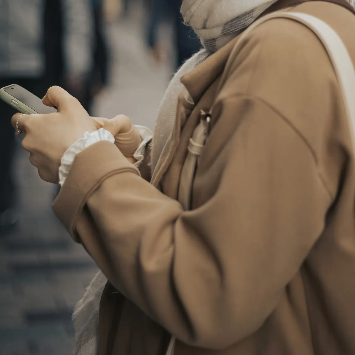 Person ordering a taxi on their smartphone on the go
